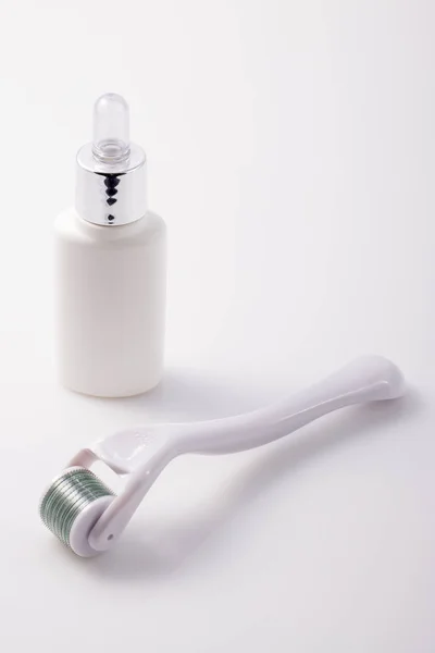 Dermaroller voor medische micro needling therapie en fles geneesmiddel. — Stockfoto