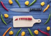 Картина, постер, плакат, фотообои "chopped cayenne chilli pepper on cutting board with other peppers all around", артикул 130775188