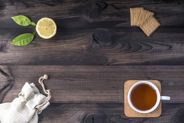 Tasse Tee mit frischer Zitrone, Teeplätzchen und Leinentasche — Stockfoto