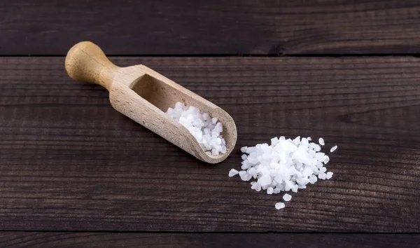 Cristales de sal con cuchara de madera y vaso salero — Foto de Stock