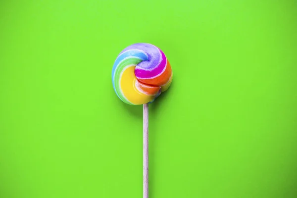 Rainbow lollipop on color background — Stock Photo, Image