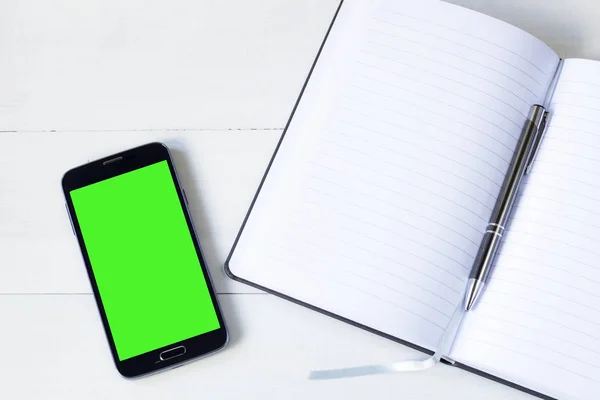 Smart phone with green screen with notepad — Stock Photo, Image