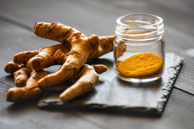 Zerdeçal tozu ve taze zerdeçal kökü.