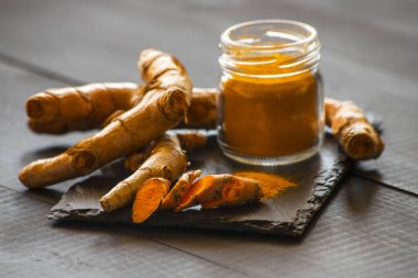 Zerdeçal tozu ve taze zerdeçal kökü.