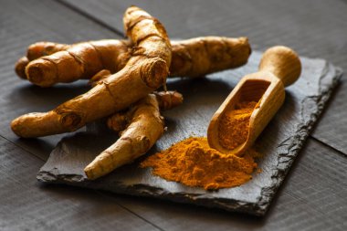 Zerdeçal tozu ve taze zerdeçal kökü.