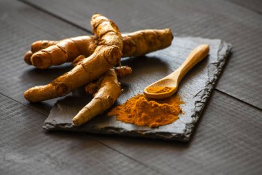 Zerdeçal tozu ve taze zerdeçal kökü.