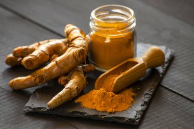 Zerdeçal tozu ve taze zerdeçal kökü.