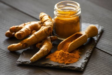 Zerdeçal tozu ve taze zerdeçal kökü.