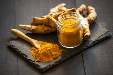 Zerdeçal tozu ve taze zerdeçal kökü.