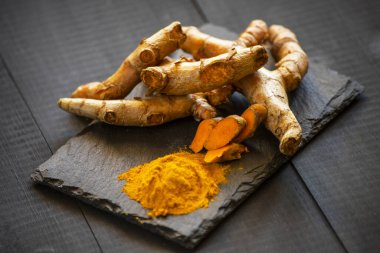 Zerdeçal tozu ve taze zerdeçal kökü.