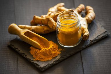 Zerdeçal tozu ve taze zerdeçal kökü.