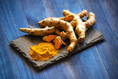 Zerdeçal tozu ve taze zerdeçal kökü.