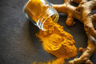 Zerdeçal tozu ve taze zerdeçal kökü.