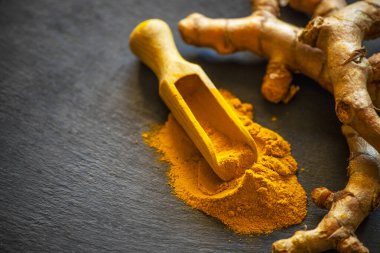 Zerdeçal tozu ve taze zerdeçal kökü.