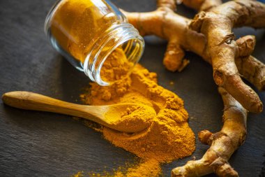 Zerdeçal tozu ve taze zerdeçal kökü.