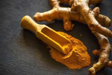 Zerdeçal tozu ve taze zerdeçal kökü.