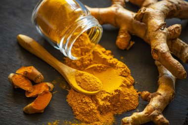 Zerdeçal tozu ve taze zerdeçal kökü.