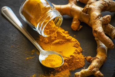 Zerdeçal tozu ve taze zerdeçal kökü.