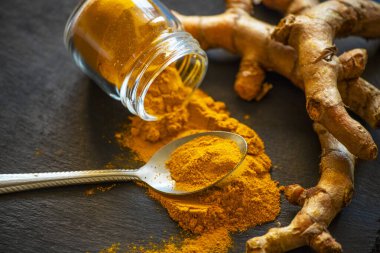 Zerdeçal tozu ve taze zerdeçal kökü.