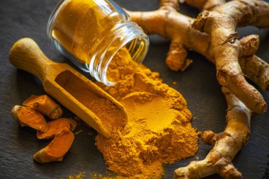 Zerdeçal tozu ve taze zerdeçal kökü.