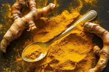 Zerdeçal tozu ve taze zerdeçal kökü.