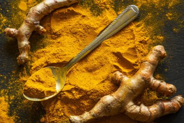 Zerdeçal tozu ve taze zerdeçal kökü.