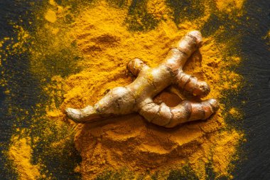 Zerdeçal tozu ve taze zerdeçal kökü.