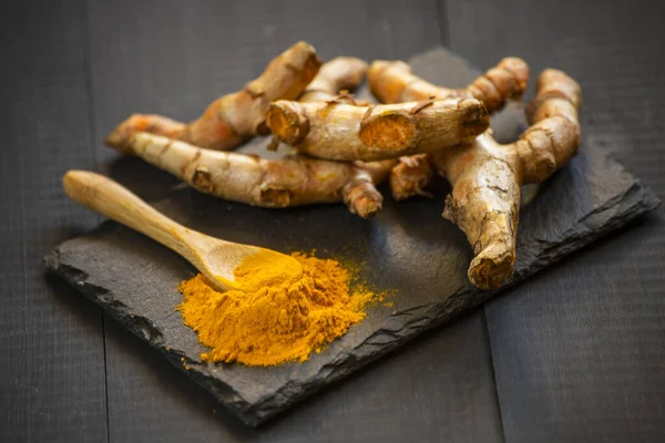 Zerdeçal tozu ve taze zerdeçal kökü.