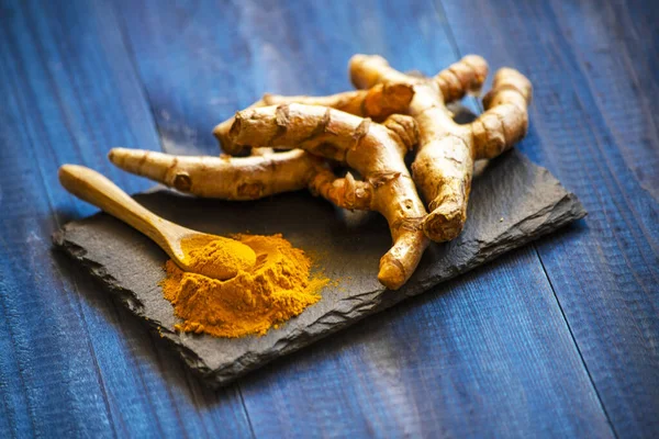 Zerdeçal tozu ve taze zerdeçal kökü.