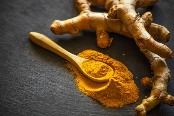 Zerdeçal tozu ve taze zerdeçal kökü.