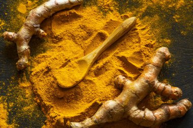 Zerdeçal tozu ve taze zerdeçal kökü.