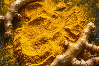 Zerdeçal tozu ve taze zerdeçal kökü.