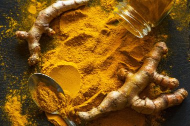 Zerdeçal tozu ve taze zerdeçal kökü.