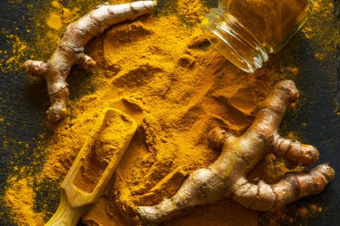 Zerdeçal tozu ve taze zerdeçal kökü.