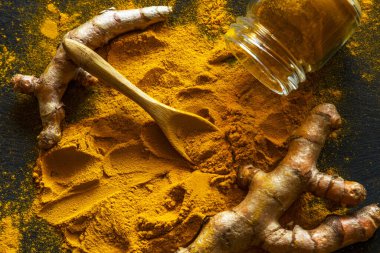 Zerdeçal tozu ve taze zerdeçal kökü.