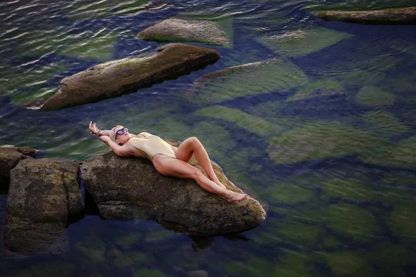 Загорелая сексуальная женщина в золотом купальнике — стоковое фото