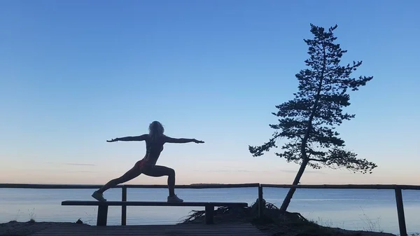 Fit kaukasische Frau praktiziert Yoga draußen Stockbild