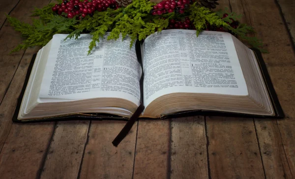 Staré rustikální Bible s vánoční věnec na dřevěné prkenné desce — Stock fotografie