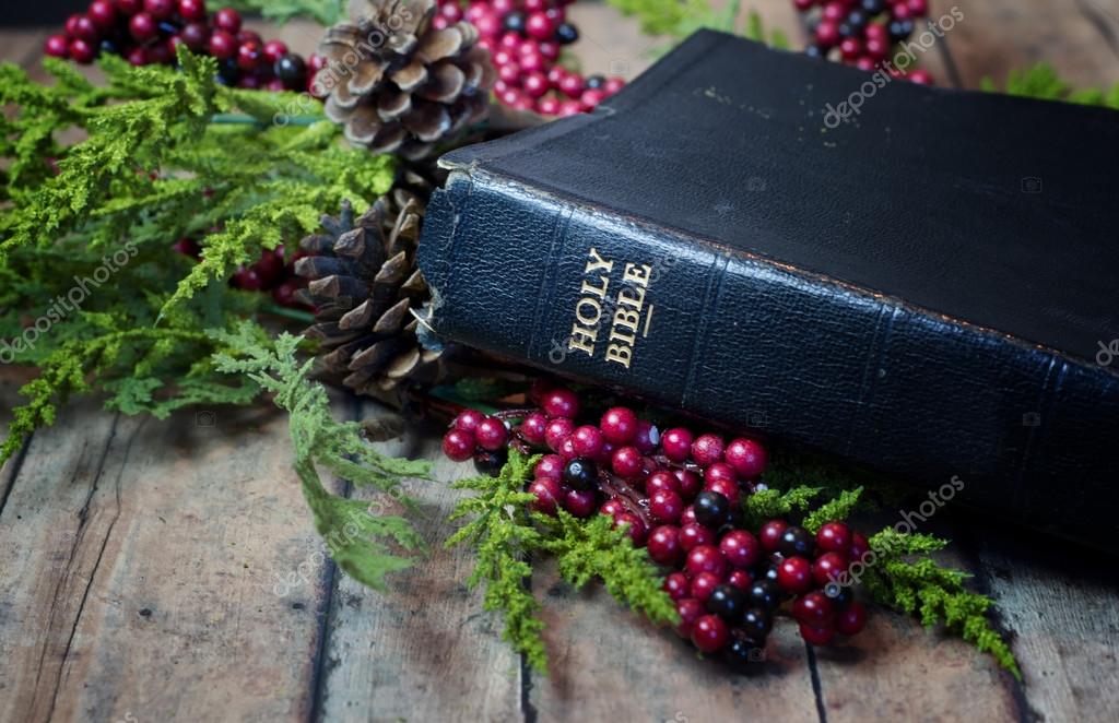 An Old Rustic Bible with Christmas Garland on a wood plank board Stock