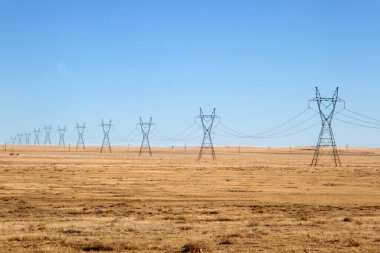 Mavi gökyüzünün altındaki elektrik hatları