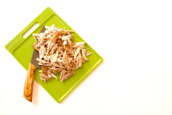 Pollo arrosto triturato su un tagliere verde e intaglio — Foto Stock