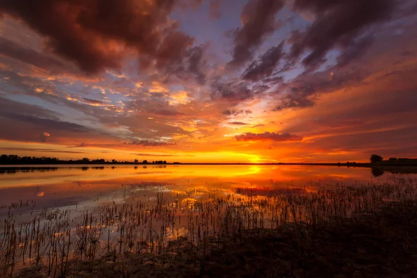 Levendige kleurrijke zonsopgang of zonsondergang reflecterende in een meer — Stockfoto