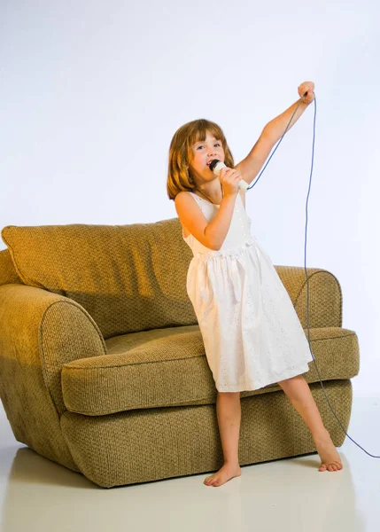 Klein meisje zingen in een microfoon. — Stockfoto
