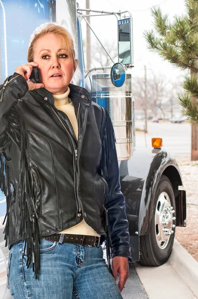 Woman truck driver talking on the cell phone to her dispatcher — Stock Photo, Image