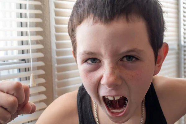 Agresywny młody chłopiec wyładowuje złość zaciśniętą pięścią. — Zdjęcie stockowe