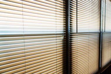 Güneş ışığı sabahın erken saatlerinde pencerenin perdelerine vuruyor.