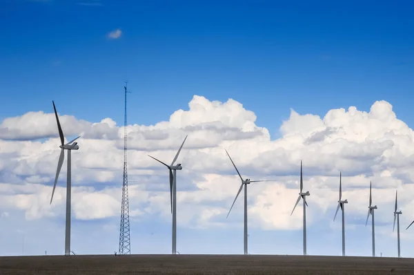 Wind turbine gererators with a cell tower on farmland — Stock Photo, Image