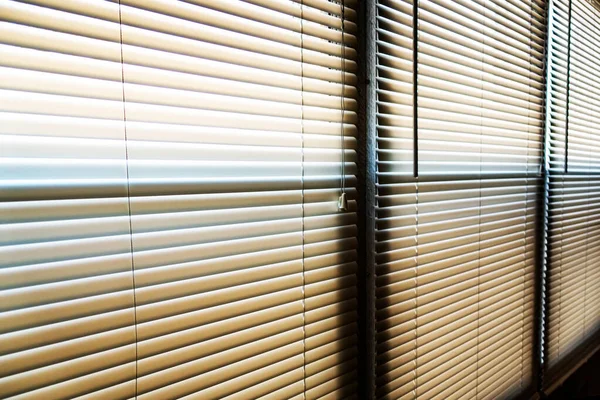 Güneş ışığı sabahın erken saatlerinde pencerenin perdelerine vuruyor.