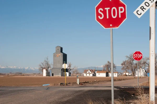 Dirt road with a railroad crossing controled with stop signs. — Stock Photo, Image