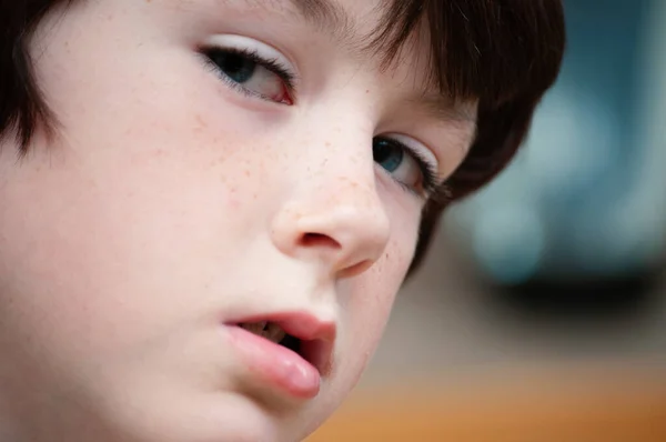 Close-up van een jonge jongen naar laten zien zijn blauwe ogen Rechtenvrije Stockafbeeldingen